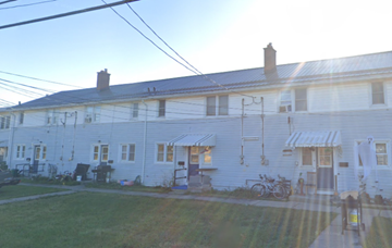 Picton apartment for rent - A white building with a blue roof and a bicycle parked in front.