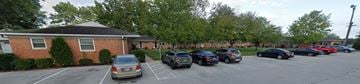 Plainfield apartment for rent - A parking lot with cars parked in front of a brick building.