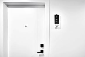 Calgary house for rent - A white door with a black dot on it and a sign on the wall that says 744 front.