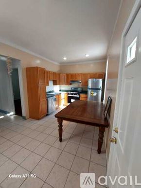 Jersey City apartment for rent - A kitchen with wooden cabinets and a white fridge is shown.