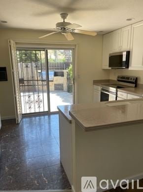 San Diego condo for rent - A kitchen with a fan on the ceiling and a countertop.