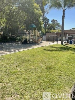 San Diego condo for rent - A playground with a slide and a green roofed structure.