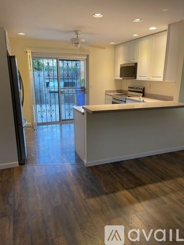 San Diego condo for rent - A kitchen with a refrigerator on the left and a microwave above the stove.