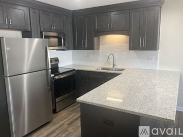 Northport apartment for rent - A kitchen with a stainless steel refrigerator and dark wood cabinets.