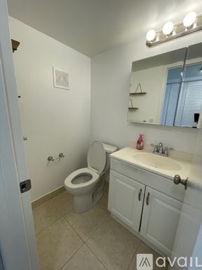 Boca Raton apartment for rent - A bathroom with a toilet, sink, and mirror.