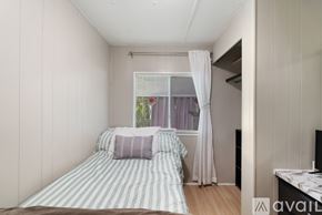 Zephyrhills house for rent - A bedroom with a bed and a window with curtains.