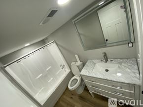 Rose Hill townhouse for rent - A modern bathroom with a walk-in shower, toilet, and sink.