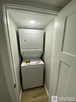 Rose Hill townhouse for rent - A small white washing machine sits in a narrow space between two walls.