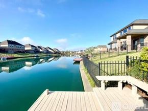 Missouri City house for rent - A wooden dock leads to a calm body of water with houses on the other side.