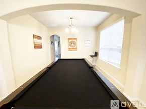 Missouri City house for rent - A room with a black pool table and a painting on the wall.