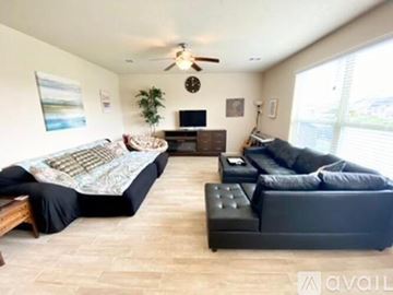 Missouri City house for rent - A living room with a black couch and a television.