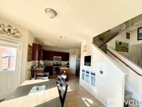 Missouri City house for rent - A kitchen with a dining table and chairs is visible from the stairs.