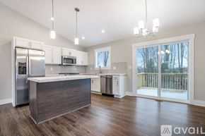 Hudsonville townhouse for rent - A kitchen with a refrigerator, microwave, and a countertop with a sink.