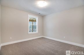 Hudsonville townhouse for rent - A room with a carpeted floor and a window with a view of trees outside.