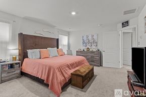 New Kent house for rent - A bedroom with a large bed and a wooden headboard.