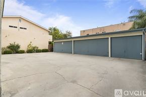 Long Beach apartment for rent - A large, empty parking lot with a building and a tree in the background.