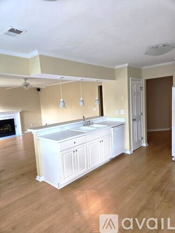 Virginia Beach house for rent - A kitchen with white cabinets and a wooden floor.