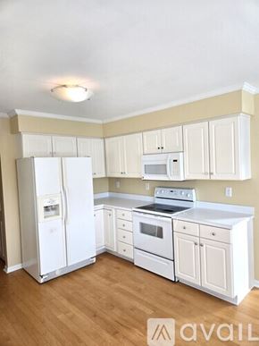 Virginia Beach house for rent - A kitchen with white appliances and cabinets.