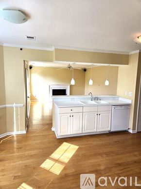 Virginia Beach house for rent - A kitchen with wooden floors and white appliances.