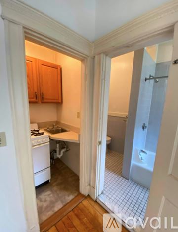 Boston apartment for rent - A small kitchen with a white stove and wooden cabinets.