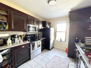 Boston apartment for rent - A kitchen with black appliances and brown cabinets.