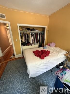Boston apartment for rent - A bedroom with a bed, a closet, and a carpeted floor.
