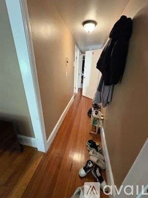 Boston apartment for rent - A hallway with shoes lined up on the floor and coats hanging on the wall.