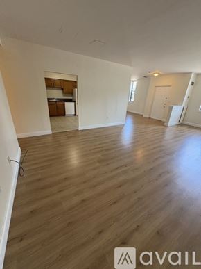 Boston apartment for rent - A spacious room with wooden flooring and white walls.