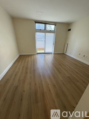Boston apartment for rent - A room with wooden flooring and a window with a view of a building outside.