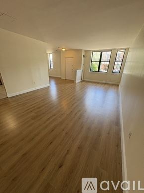 Boston apartment for rent - A spacious room with wooden flooring and a window.