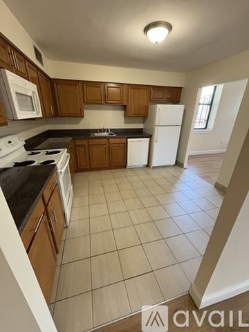 Boston apartment for rent - A kitchen with wooden cabinets and white appliances.