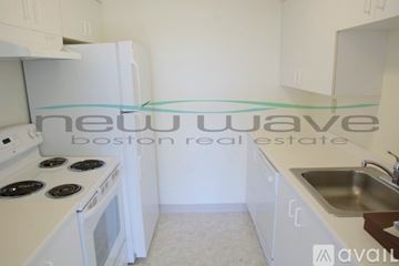 Boston apartment for rent - A kitchen with a white stove top oven and white cabinets.