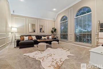Plano house for rent - A living room with a large rug and a black couch.