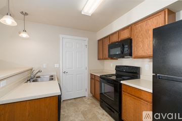 Spokane Valley apartment for rent - A kitchen with black appliances and wooden cabinets.