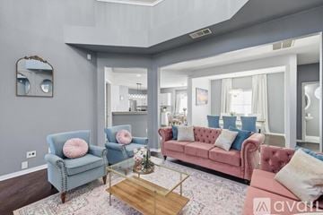 Lewisville house for rent - A living room with a pink sofa and blue chairs.