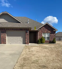 Centerton house for rent - A house with a brown roof and a white garage door.