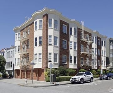 San Francisco apartment for rent - A white and brown building with fire escapes on the side.