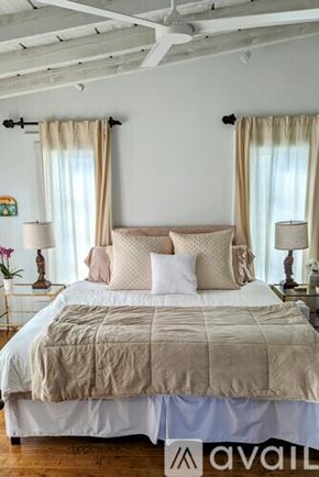 San Diego house for rent - A bed with a beige comforter and pillows is in the image.