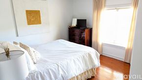 San Diego house for rent - A bedroom with a white bed and a wooden dresser.