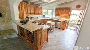 San Diego house for rent - A kitchen with wooden cabinets and a stone fireplace.