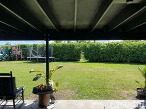 Miami house for rent - A patio with a table, chairs, and a potted plant.