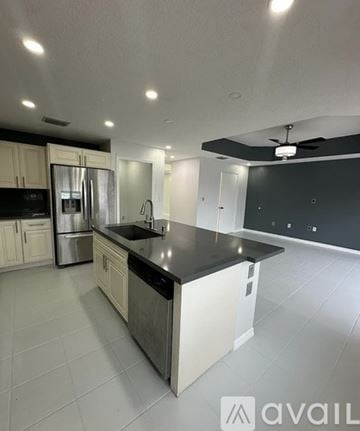 Miami house for rent - A kitchen with white cabinets and a black countertop.