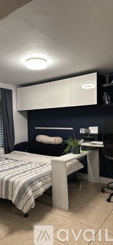 Miami house for rent - A bedroom with a bed, desk, and chair.