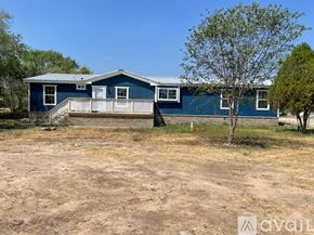 Atascosa apartment for rent - A blue house with a white porch and a tree in front.
