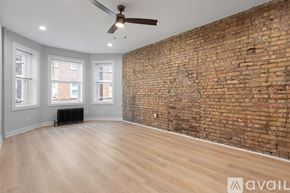 Chicago apartment for rent - A room with a brick wall and wooden flooring.