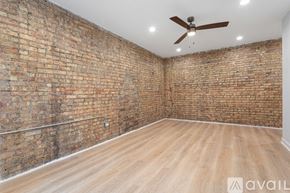 Chicago apartment for rent - A room with a brick wall and wooden floor.