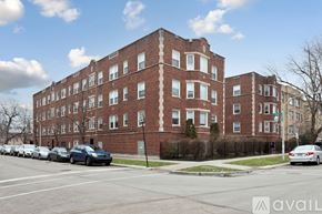 Chicago apartment for rent - A row of parked cars in front of a red brick building.