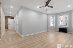 Chicago apartment for rent - A spacious room with wooden floors and a ceiling fan.