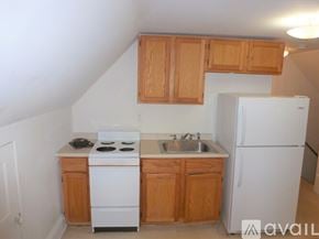 Burlington apartment for rent - A kitchen with white appliances and wooden cabinets.