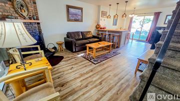 Red Lodge condo for rent - A living room with a brown couch and a wooden floor.